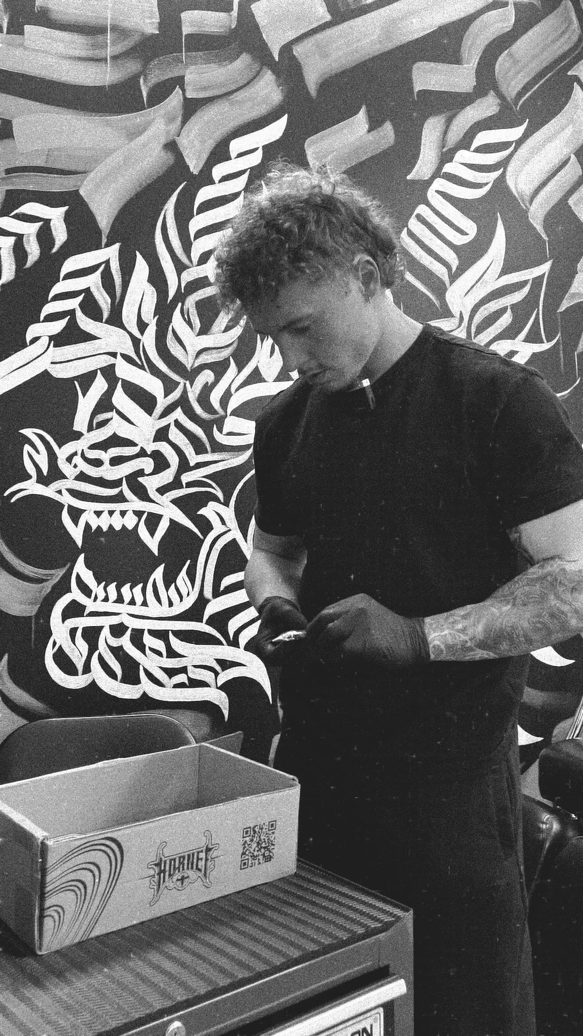 Filip working in front of freehand Maori artwork at Infinity Tattoo Studio