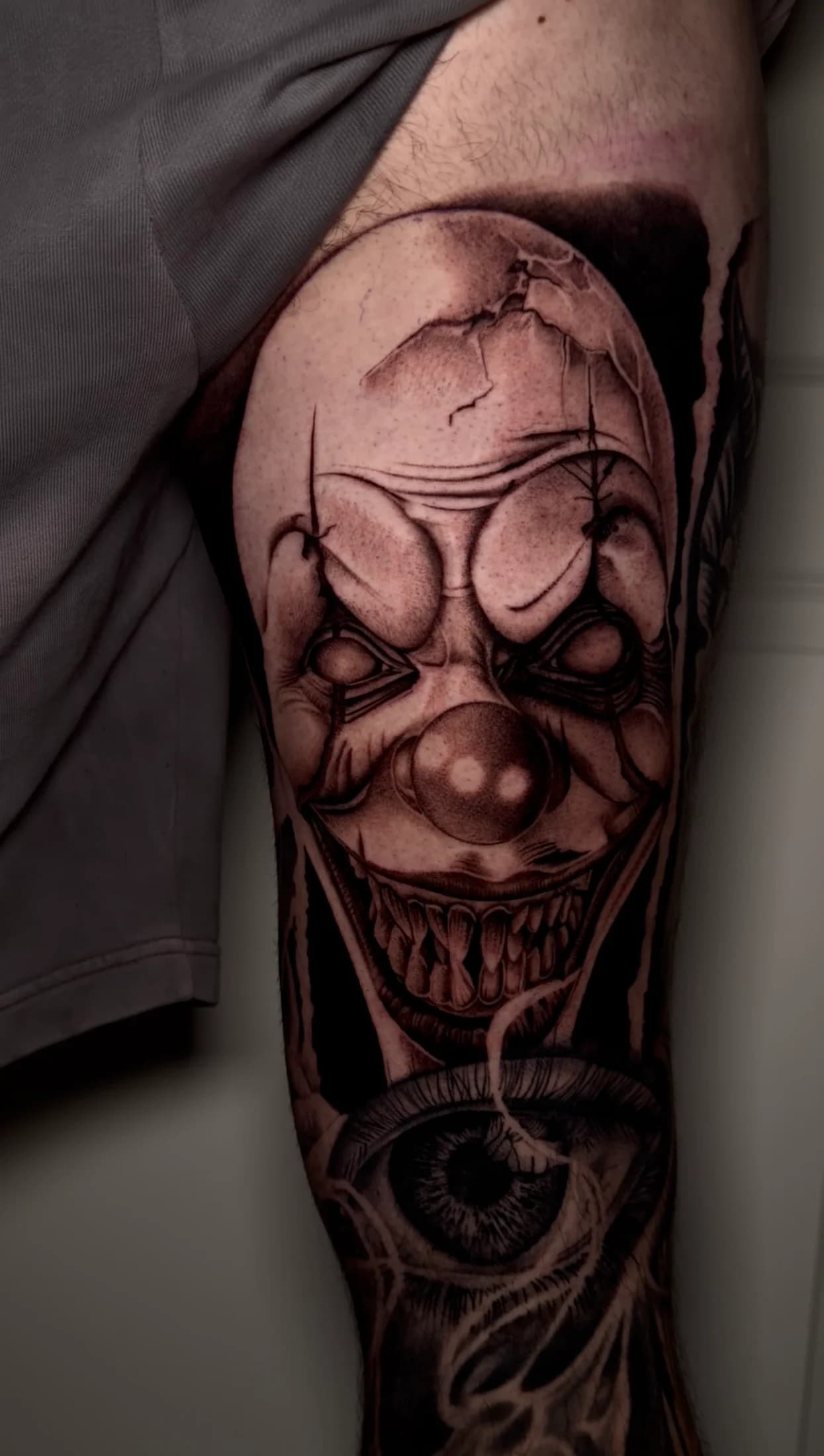 Large black and grey clown leg sleeve tattoo